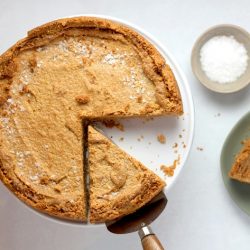 A pumpkin pie with two slices removed.